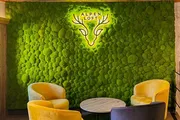 Mooswand aus Kugelmoos mit leuchtendem Alpen-Loft-Logo