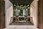 Waschtisch vor einer Pflanzenwand mit Blüten im Quellenhof Luxury Resort