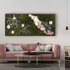 Moosbild mit weißen und rosa Blüten über einem rosa Sofa